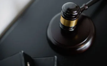 Mahkeme salonunda hâkim tokmağı ve dava dosyaları, infaz hesaplama ve koşullu salıverilme konusunu temsil ediyor
